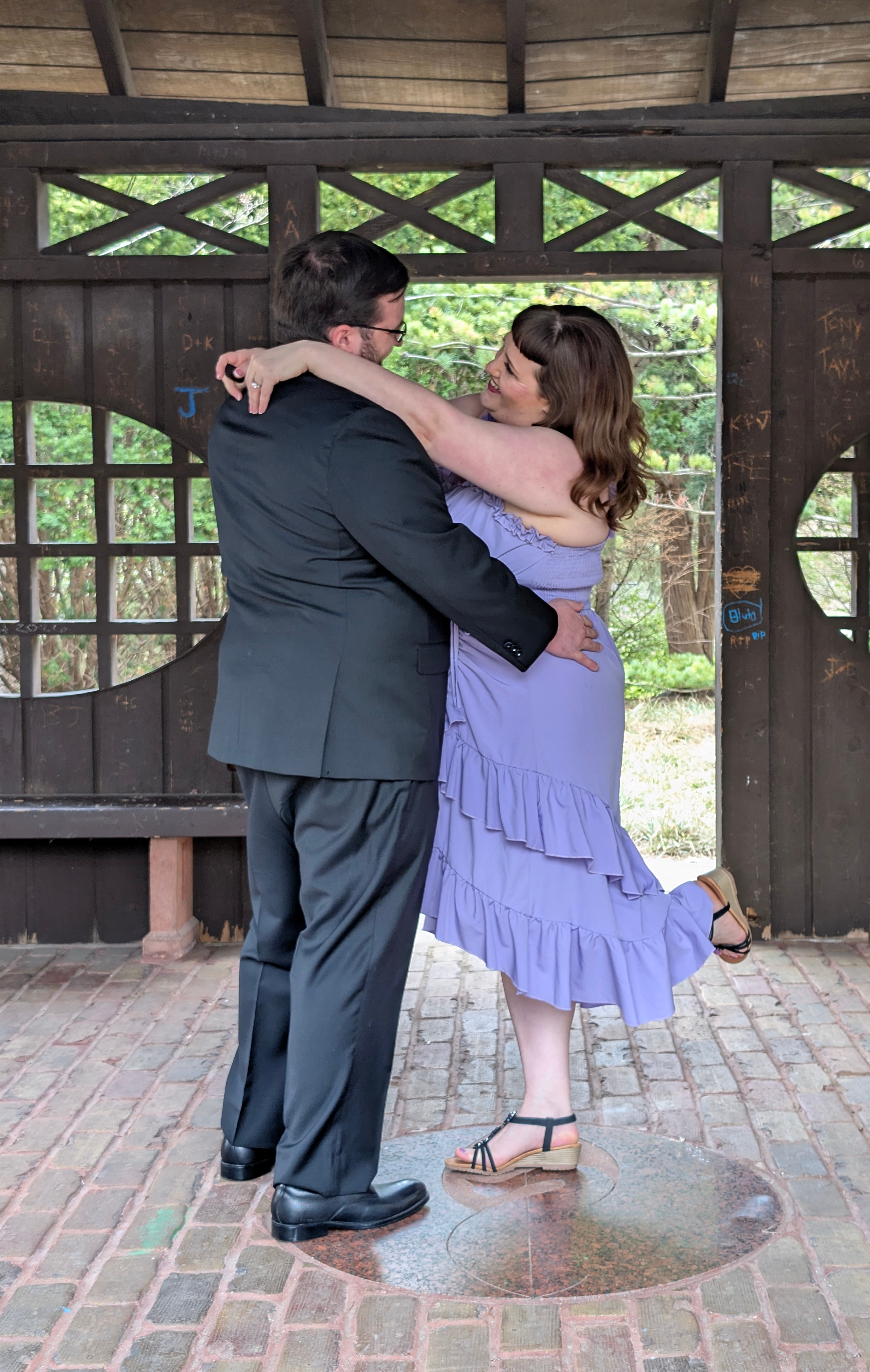 Marina and Randall embracing while dancing in a pavilion.